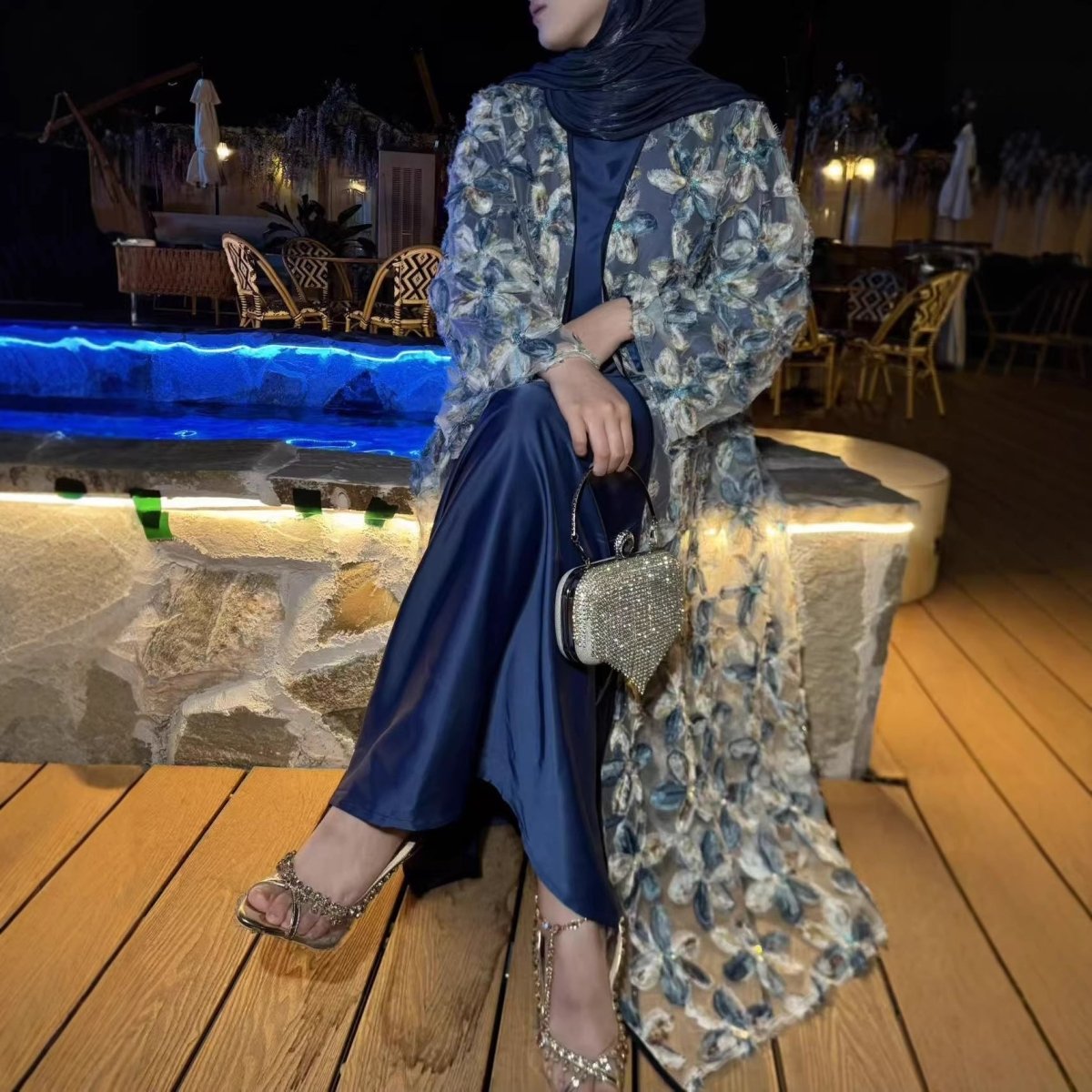 Full-length side view showing navy satin inner dress, coordinating waist belt and draped open mesh outer abaya