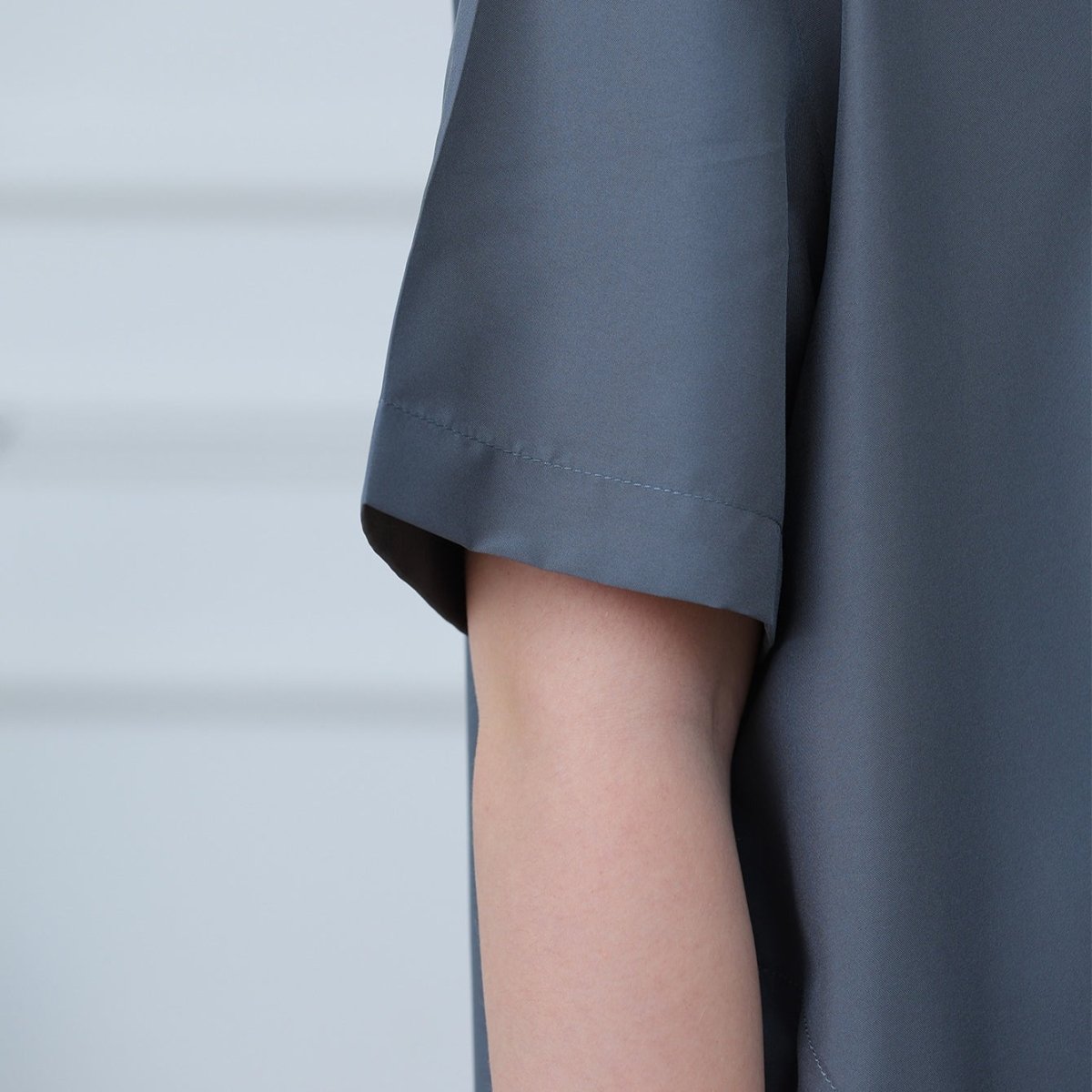 Round neckline and geometric silver embroidery detail on kids' thobe