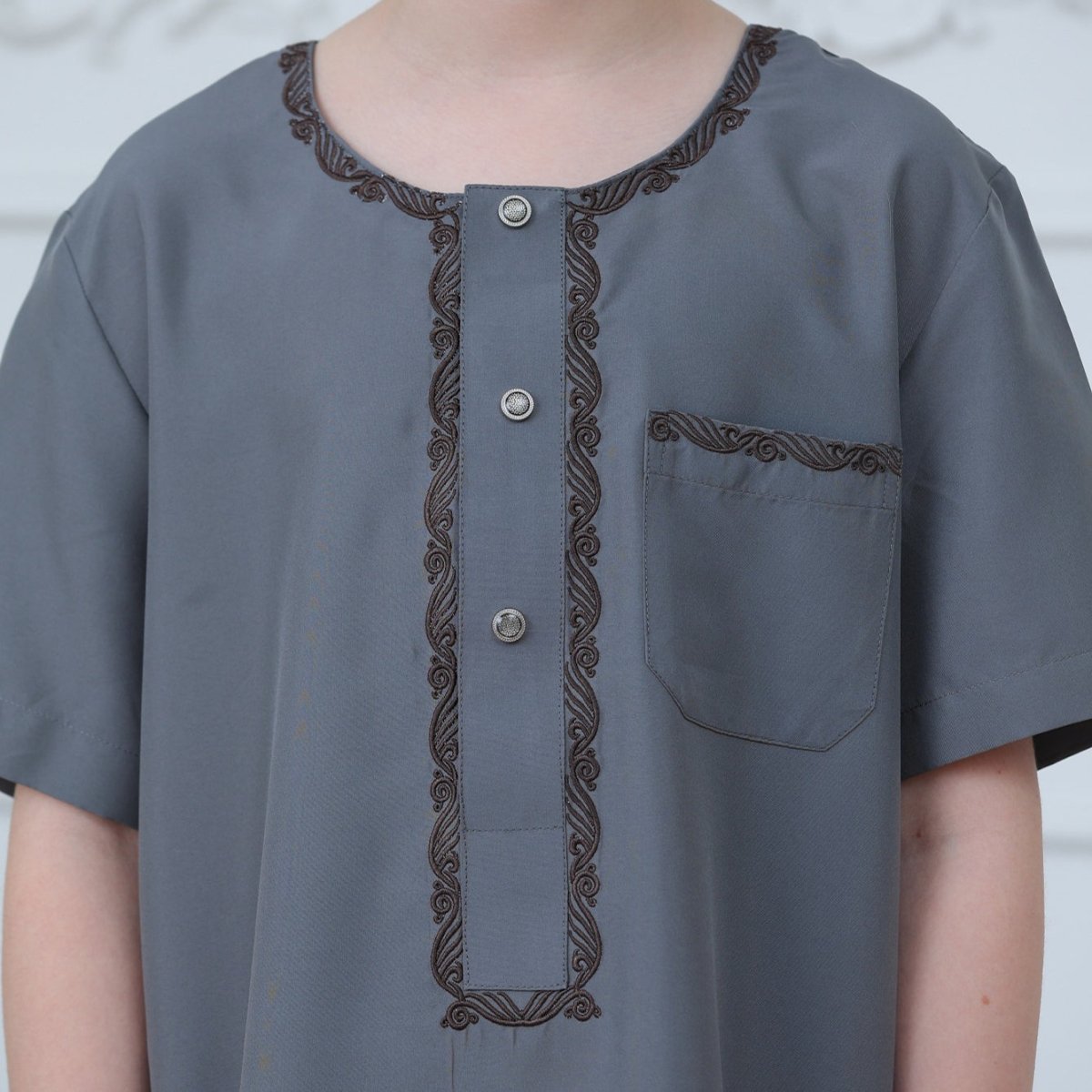 Side view showing side seam pockets on boys' ankle-length charcoal thobe