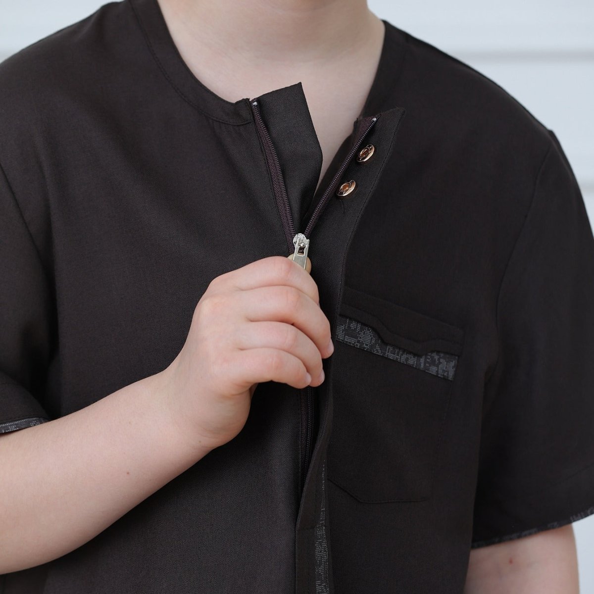 Side view showing ankle-length silhouette and short sleeves of kids' thobe