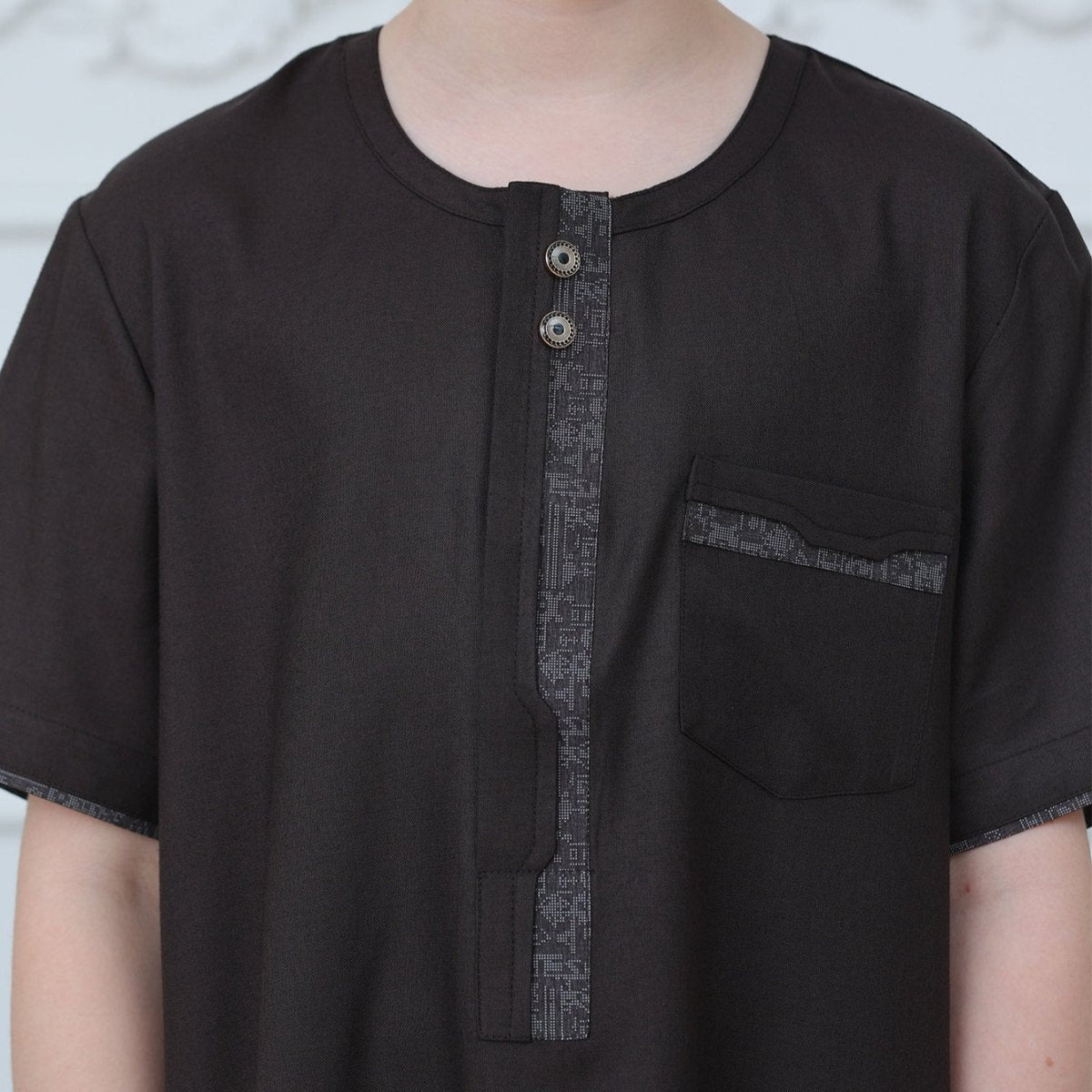 Front zipper closure detail on boys' black embroidered thobe