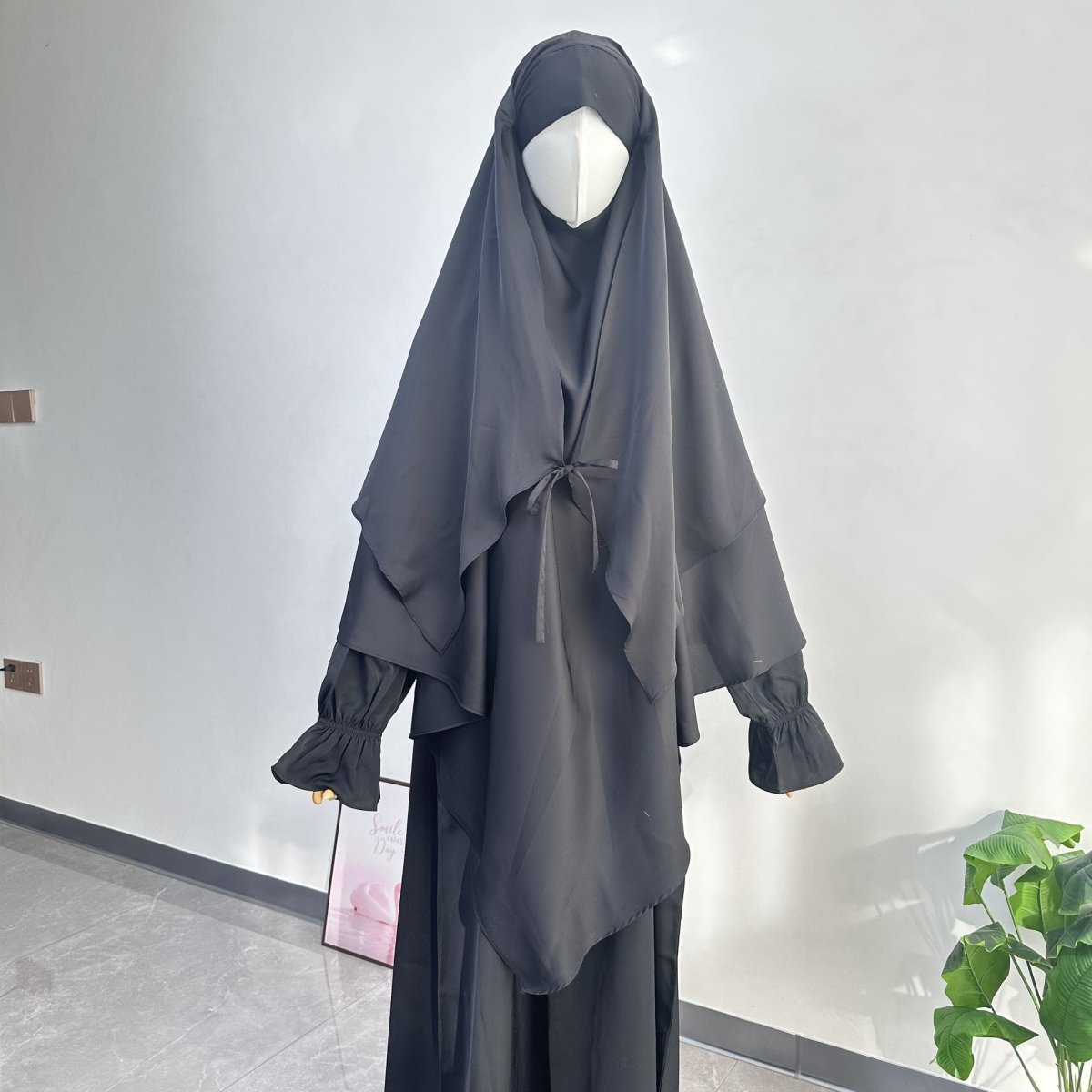 Back view of tie-front khimar showing flowing outer cape and hip-length coverage