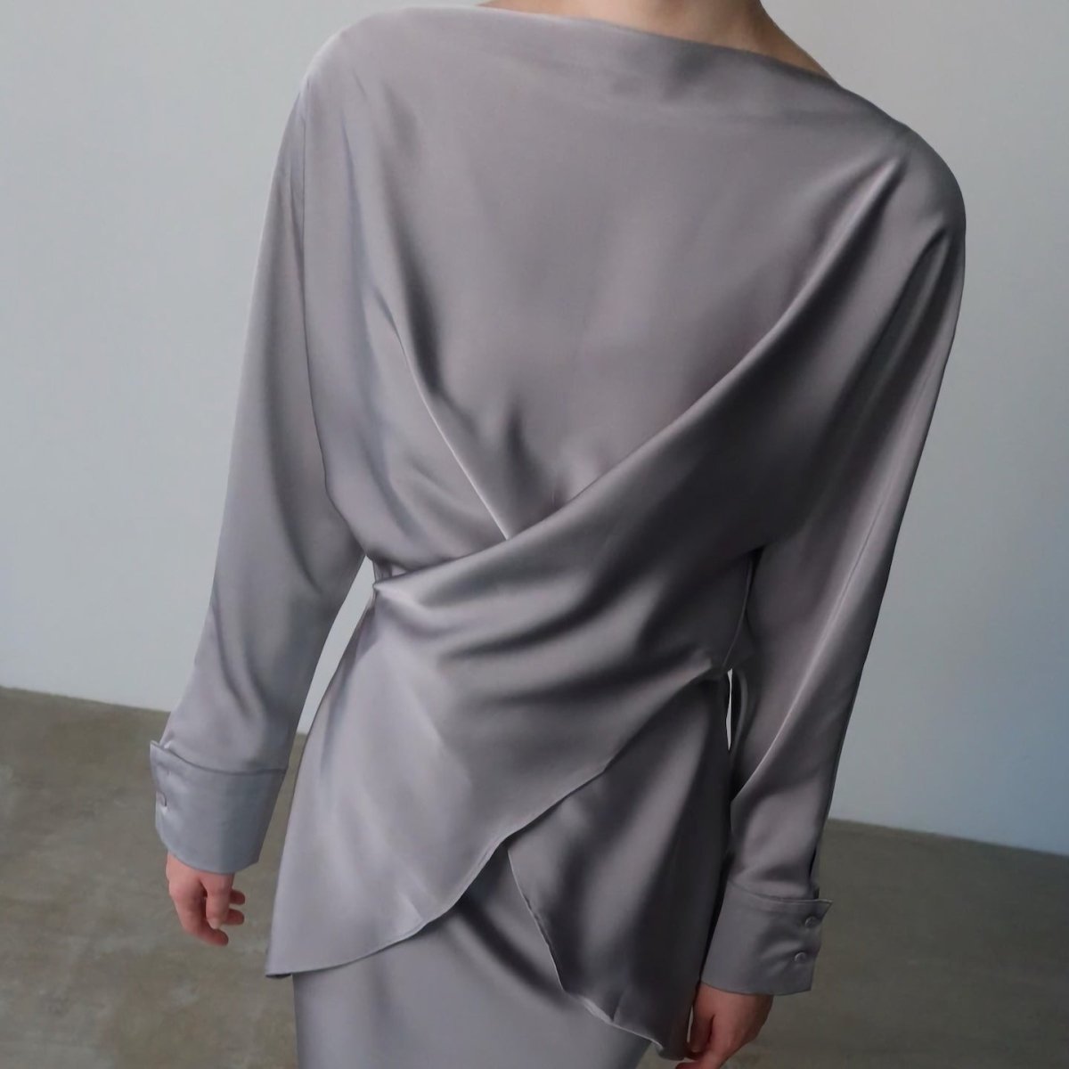 Lifestyle shot of satin draped wrap top and skirt outfit
