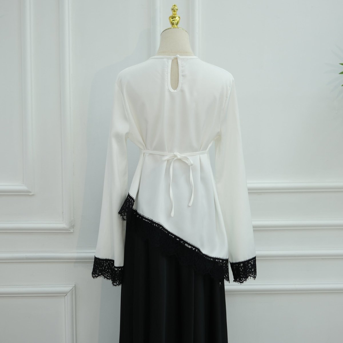 Full-length back view of black satin top with white contrast lace cuffs
