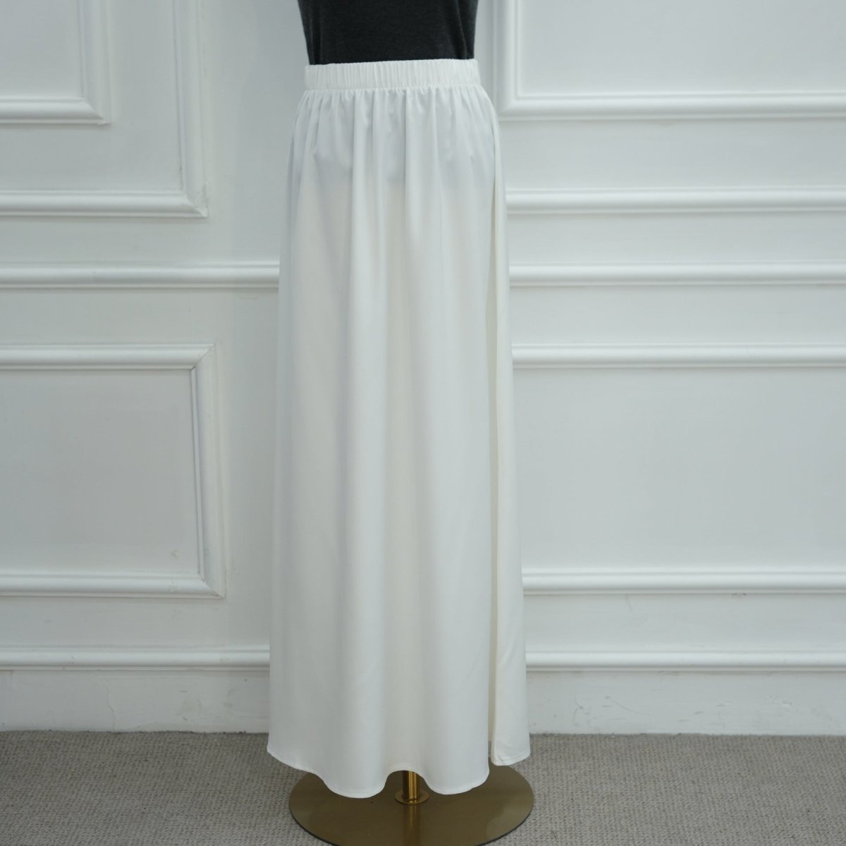 Lace trim detail at hem with model standing against neutral background