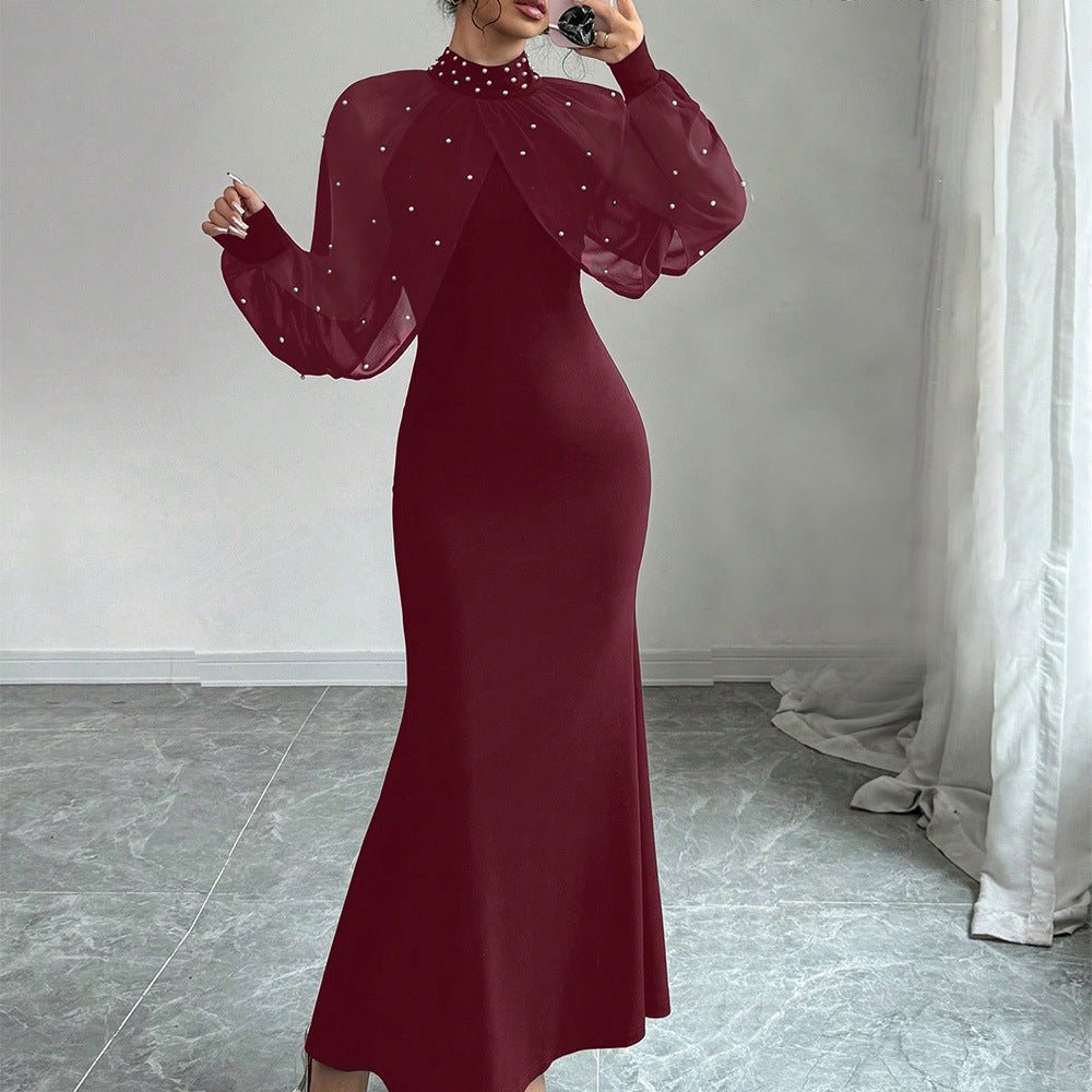 Model wearing black pearl-studded dress at floor length showing full hem