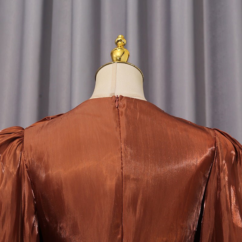 Close-up of sculptural twisted bow knot waist on satin pleat dress