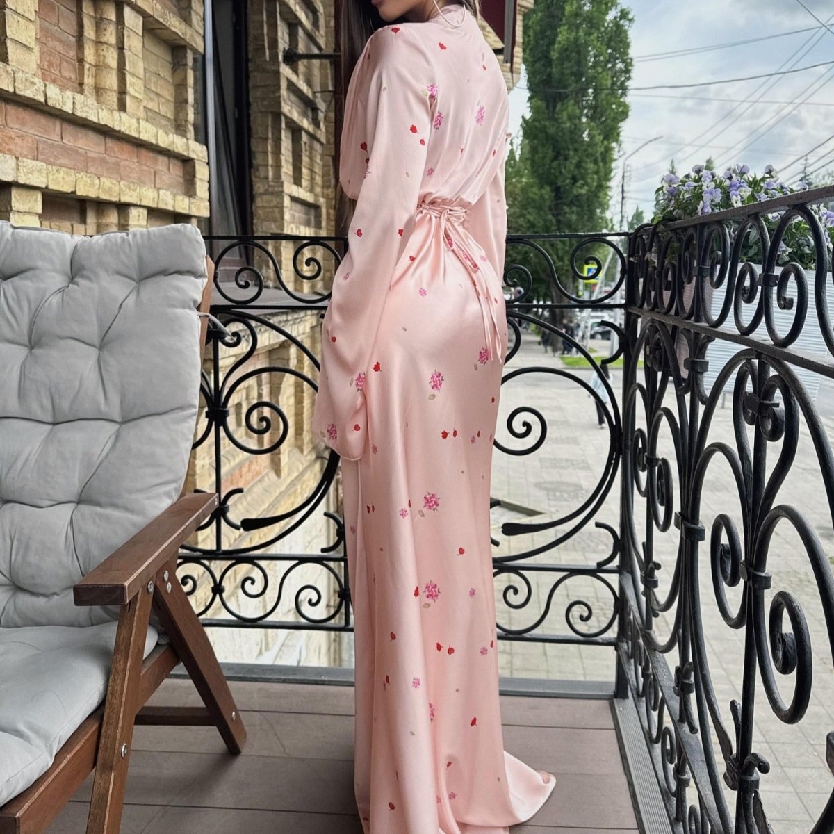 Full-length back view of flowing A-line satin wrap dress in blush pink