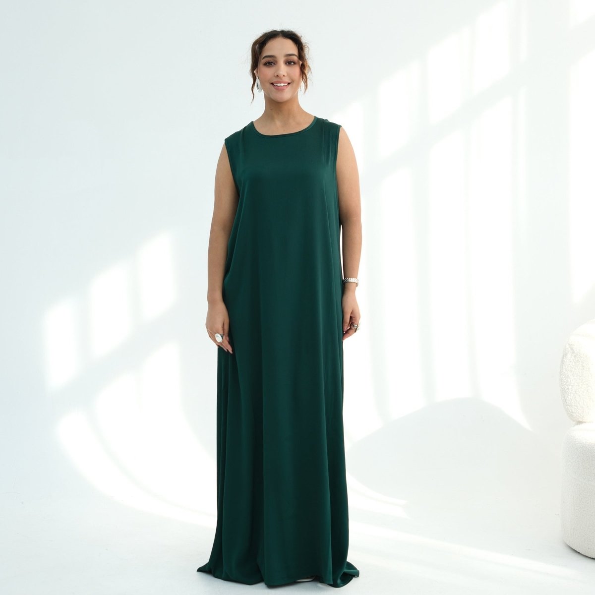Side profile of oversized sleeveless maxi dress showing floor-length drape