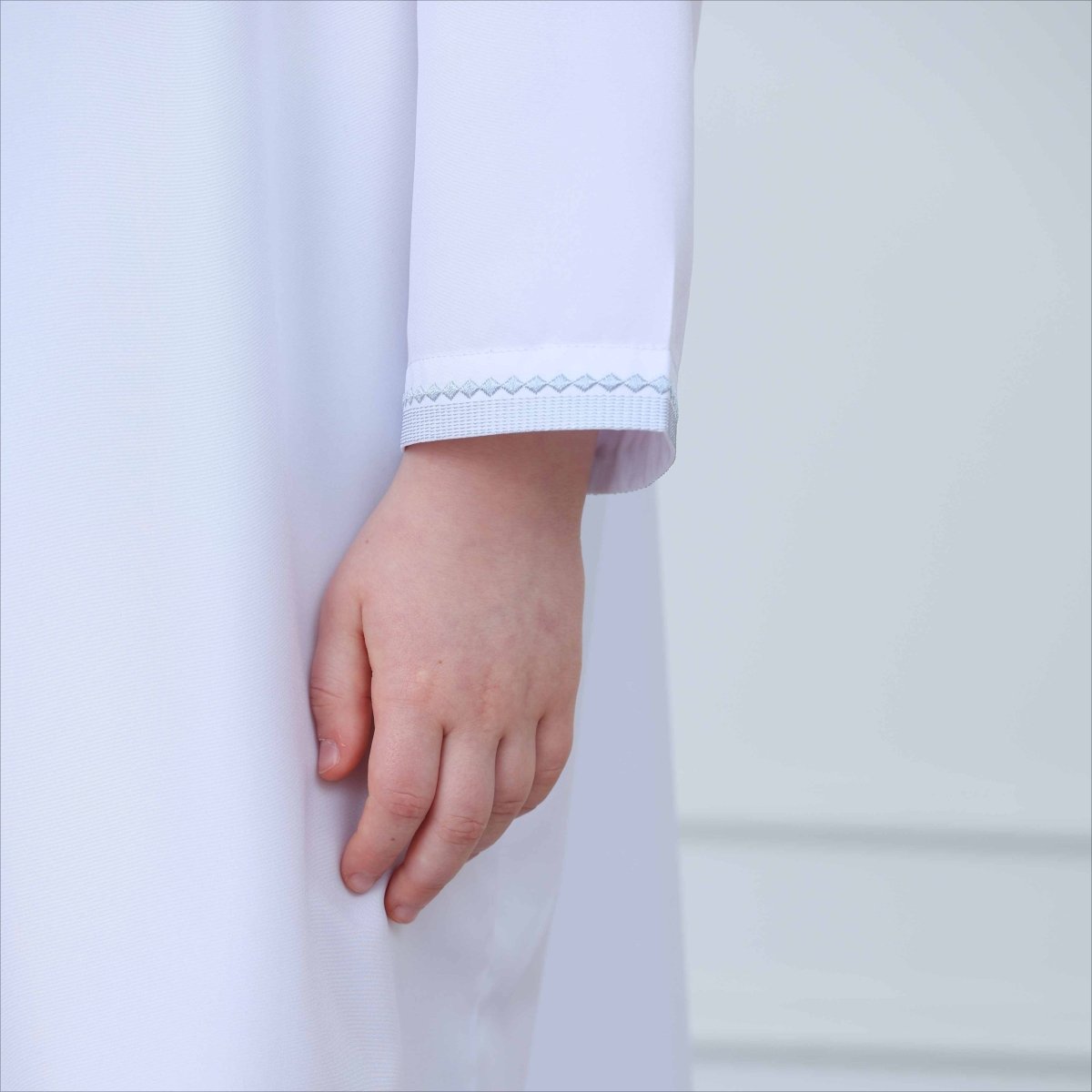 Decorative tassel tie detail at neckline of boys kids thobe