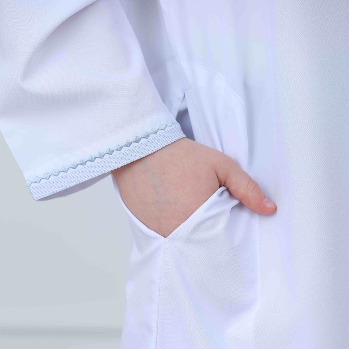 Side pocket and sleeve trim detail on embroidered kids thobe