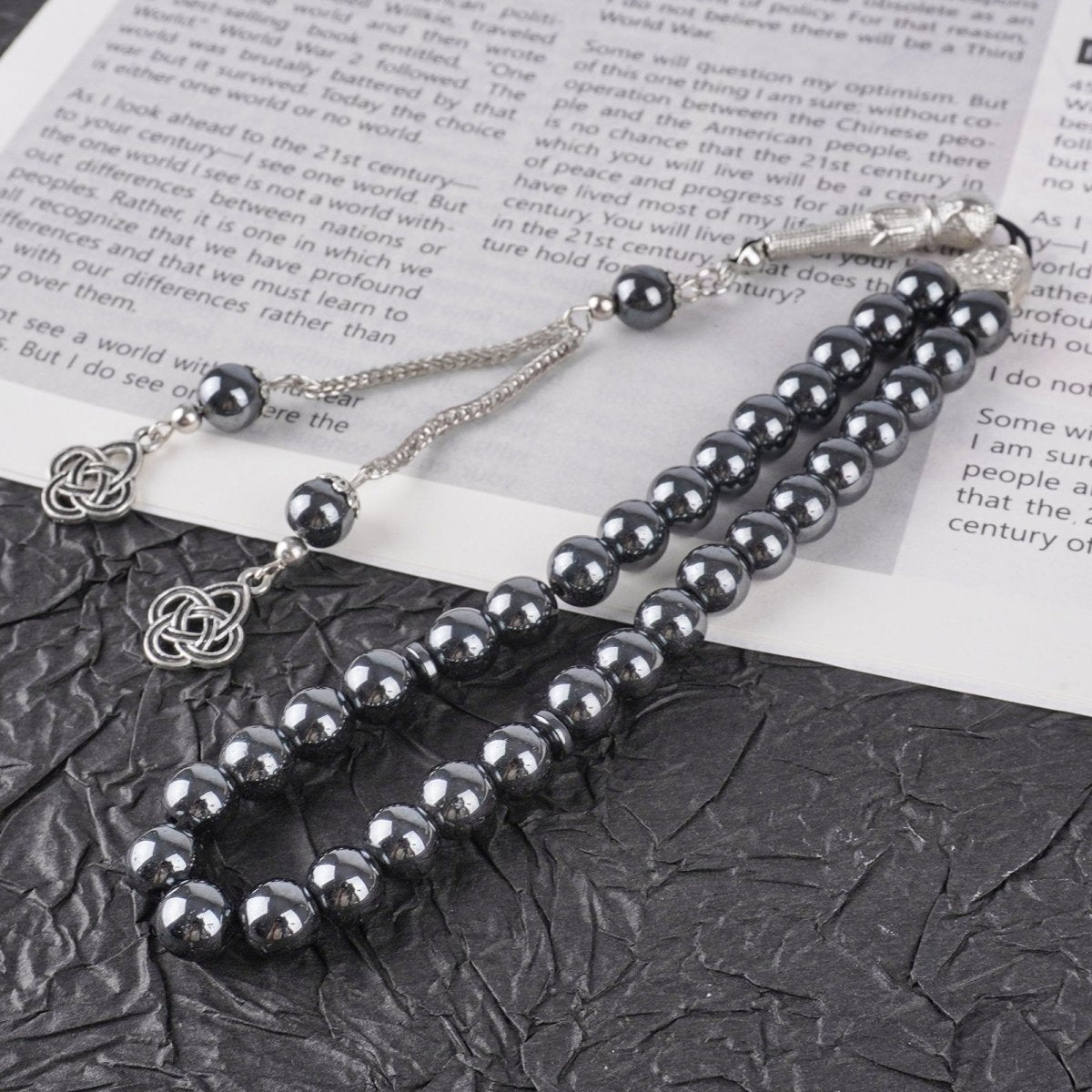 Detail of openwork floral silver pendants and obsidian bead ends on misbaha tassel