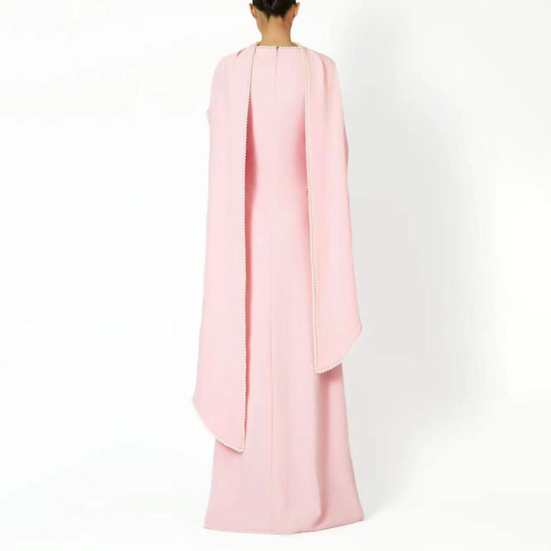 Close-up of delicate pearl trim along neckline and cape edges