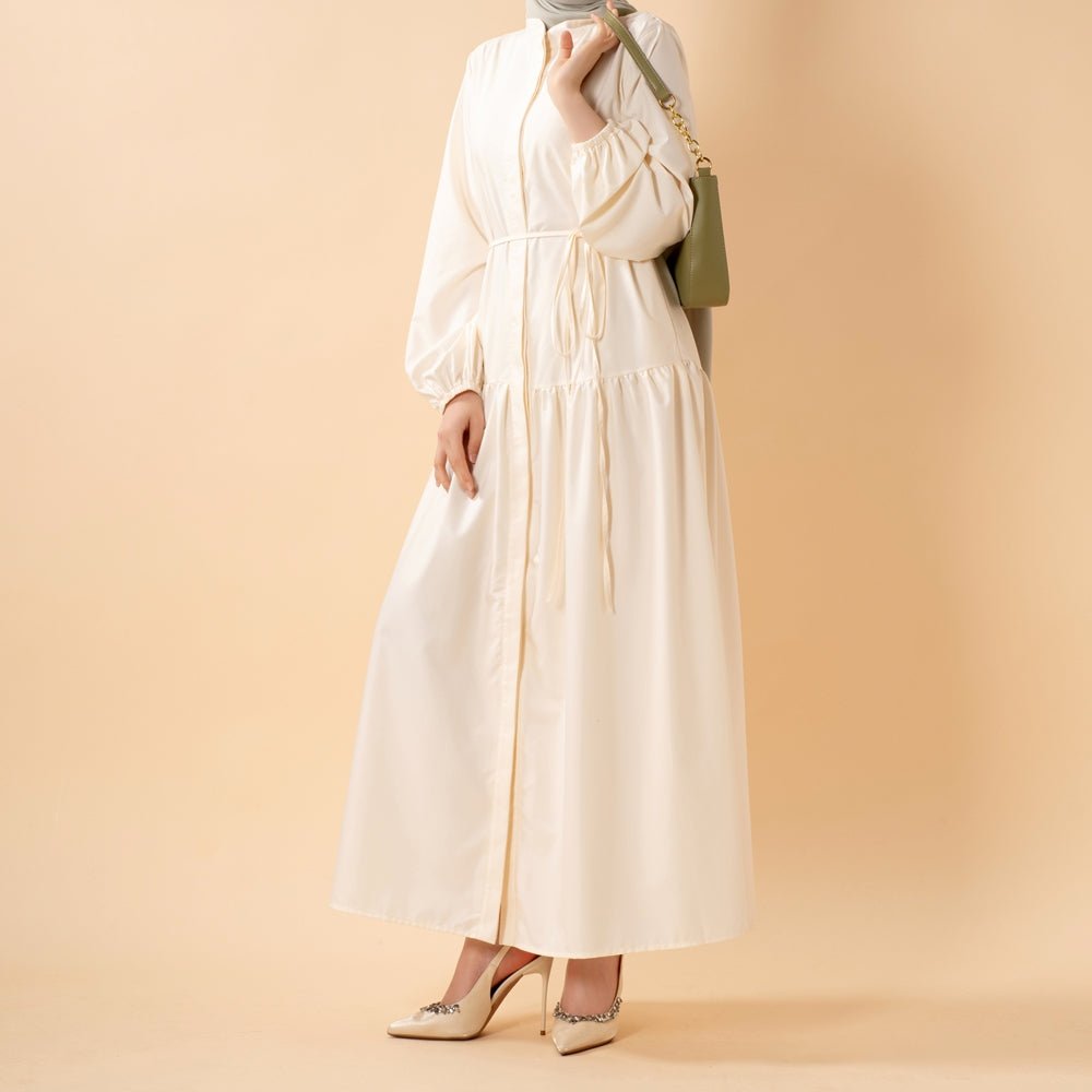 Three-quarter view of modest trench shirt dress with belt tied