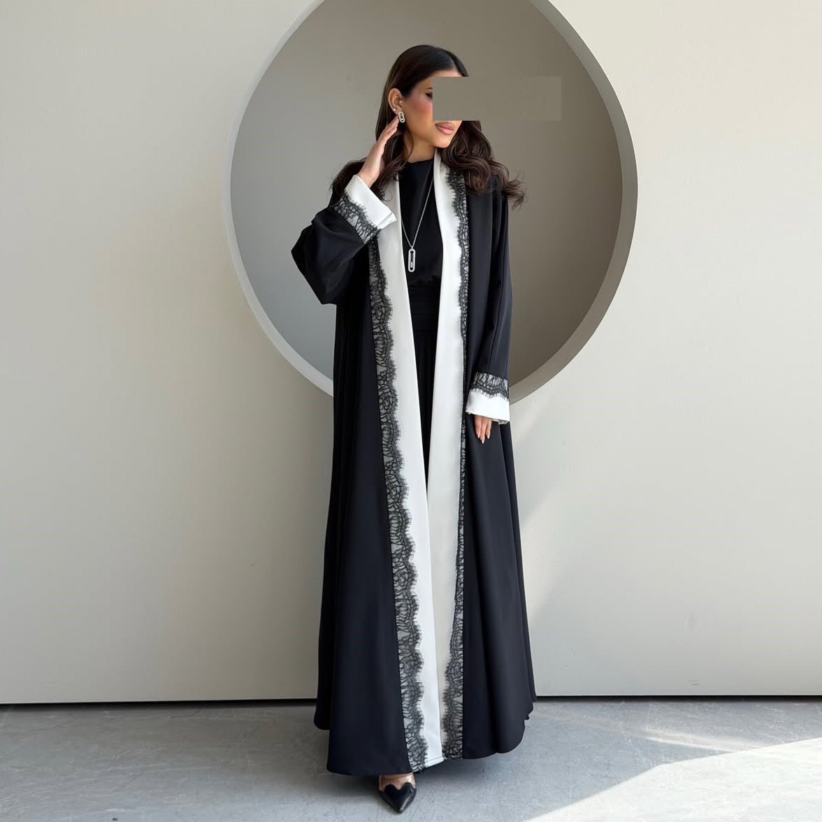 Front view showing bold black and white contrast panel stripe on open abaya