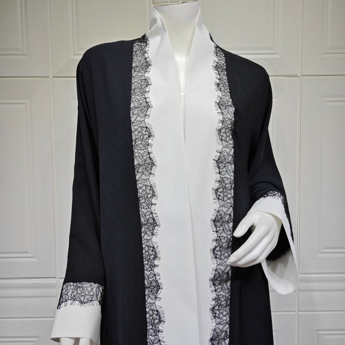 Side view of floor-length relaxed silhouette on black and white open abaya