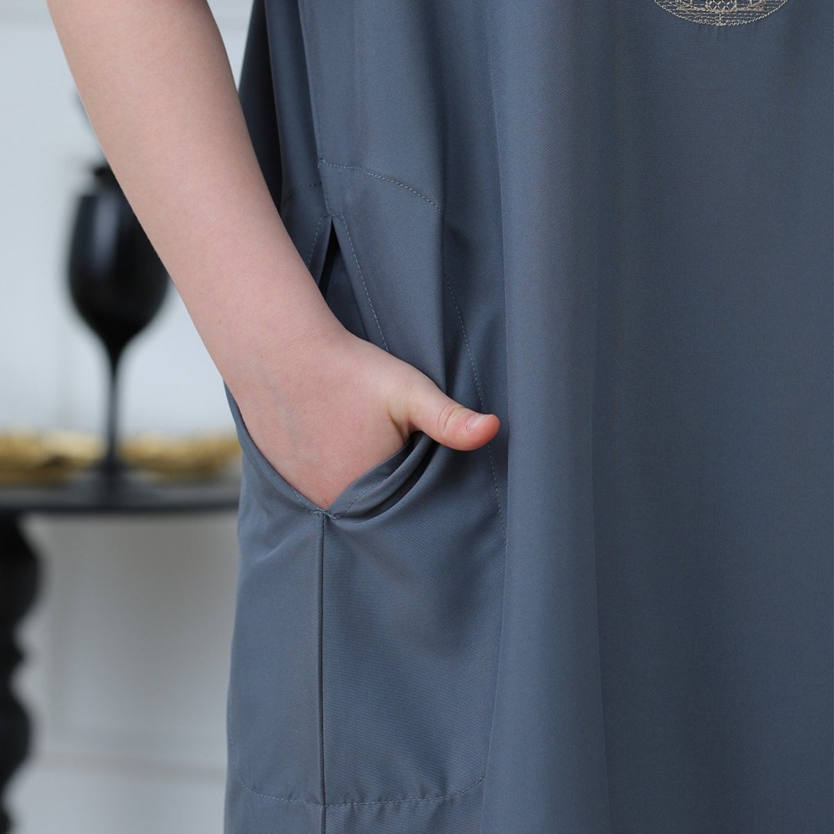 Full-length ankle-cut view of boys' slate blue embroidered thobe