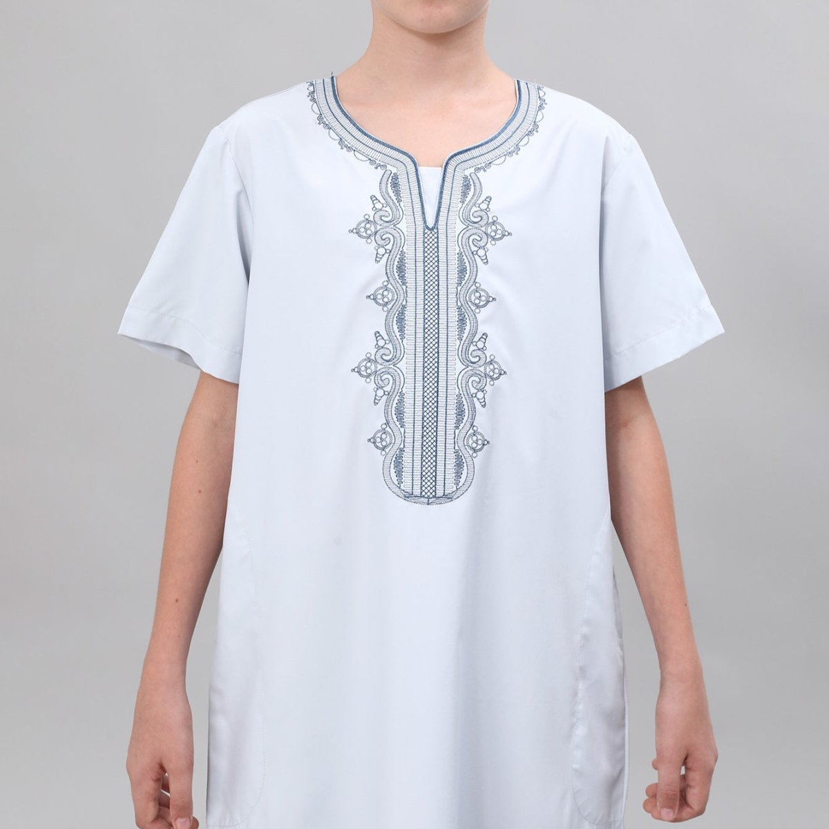 Close-up of traditional pattern embroidery on boys' white thobe placket