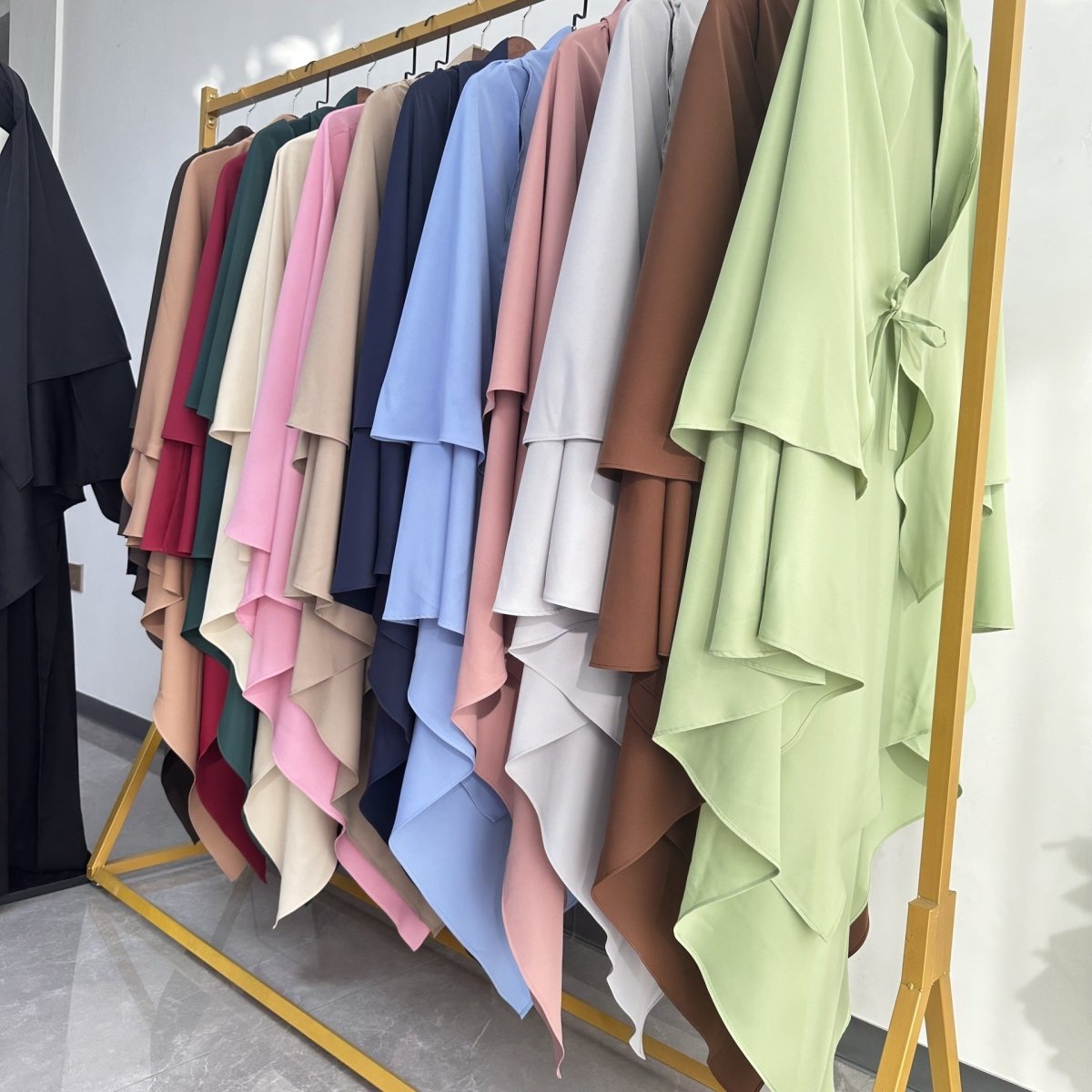 Side profile of nida prayer khimar showing asymmetric pointed hem