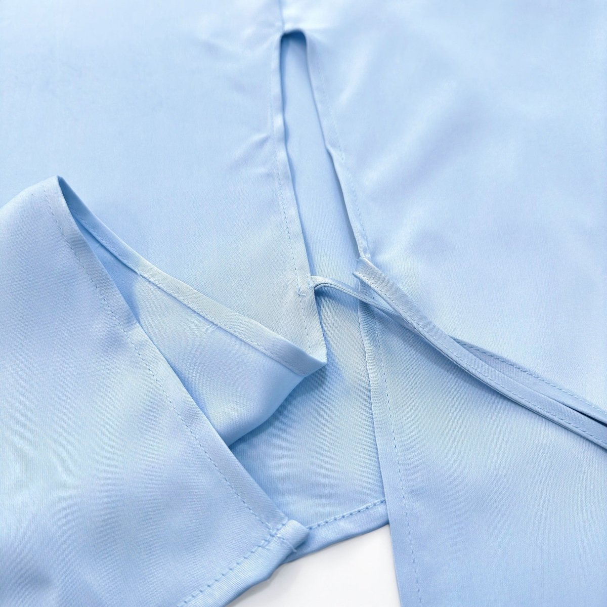 Asymmetric peplum overlay wrapping across the body