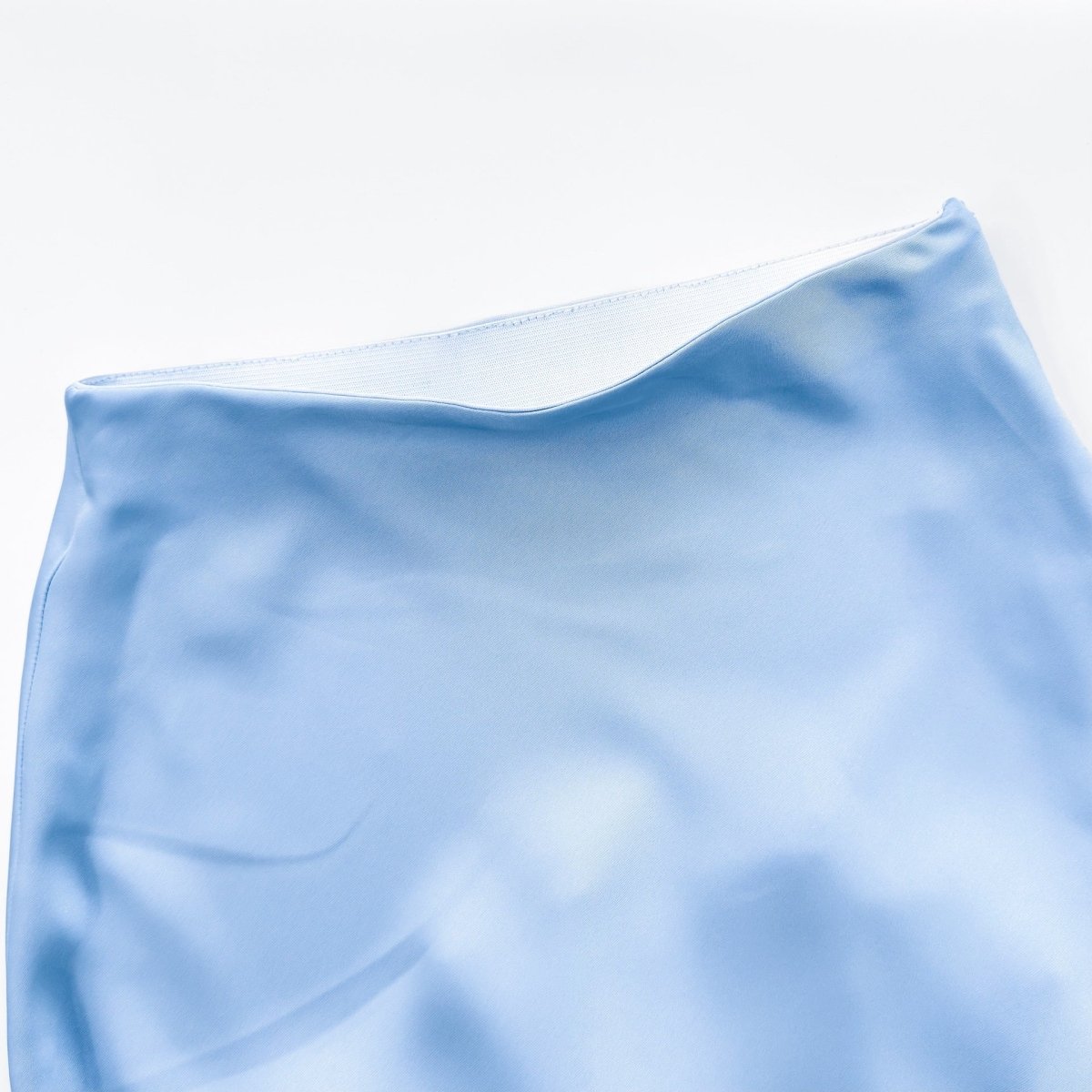 Hemline detail of A-line satin maxi skirt