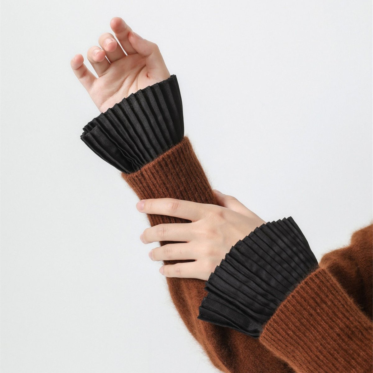 Black accordion pleated cuff sleeves with refined button closure