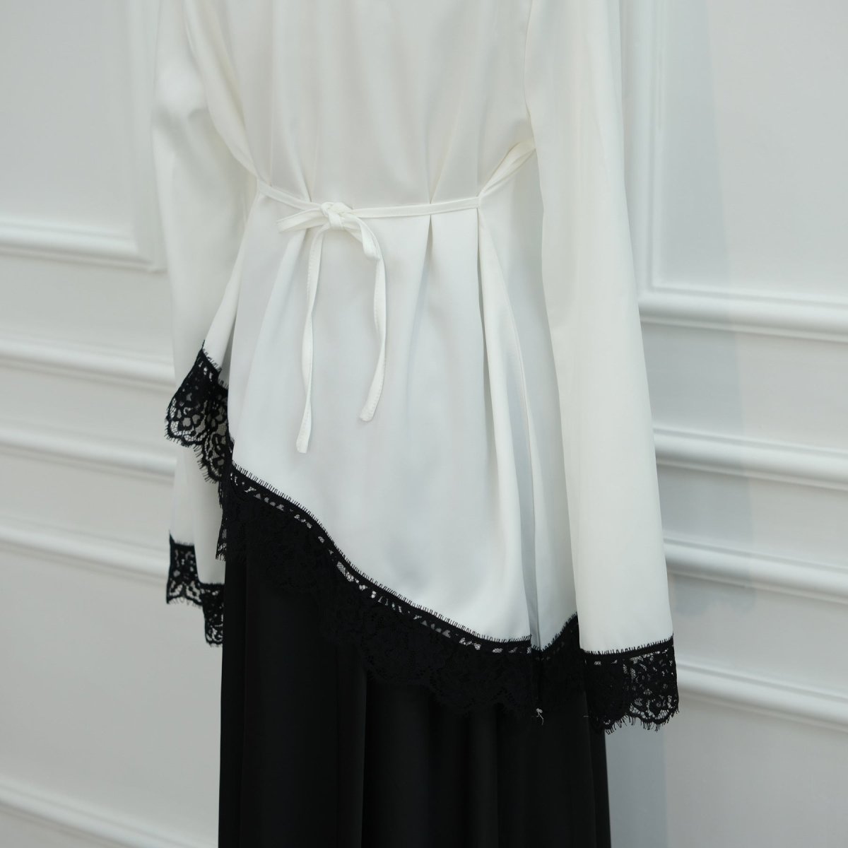 Self-tie waist ribbon cinched for structured silhouette on satin top