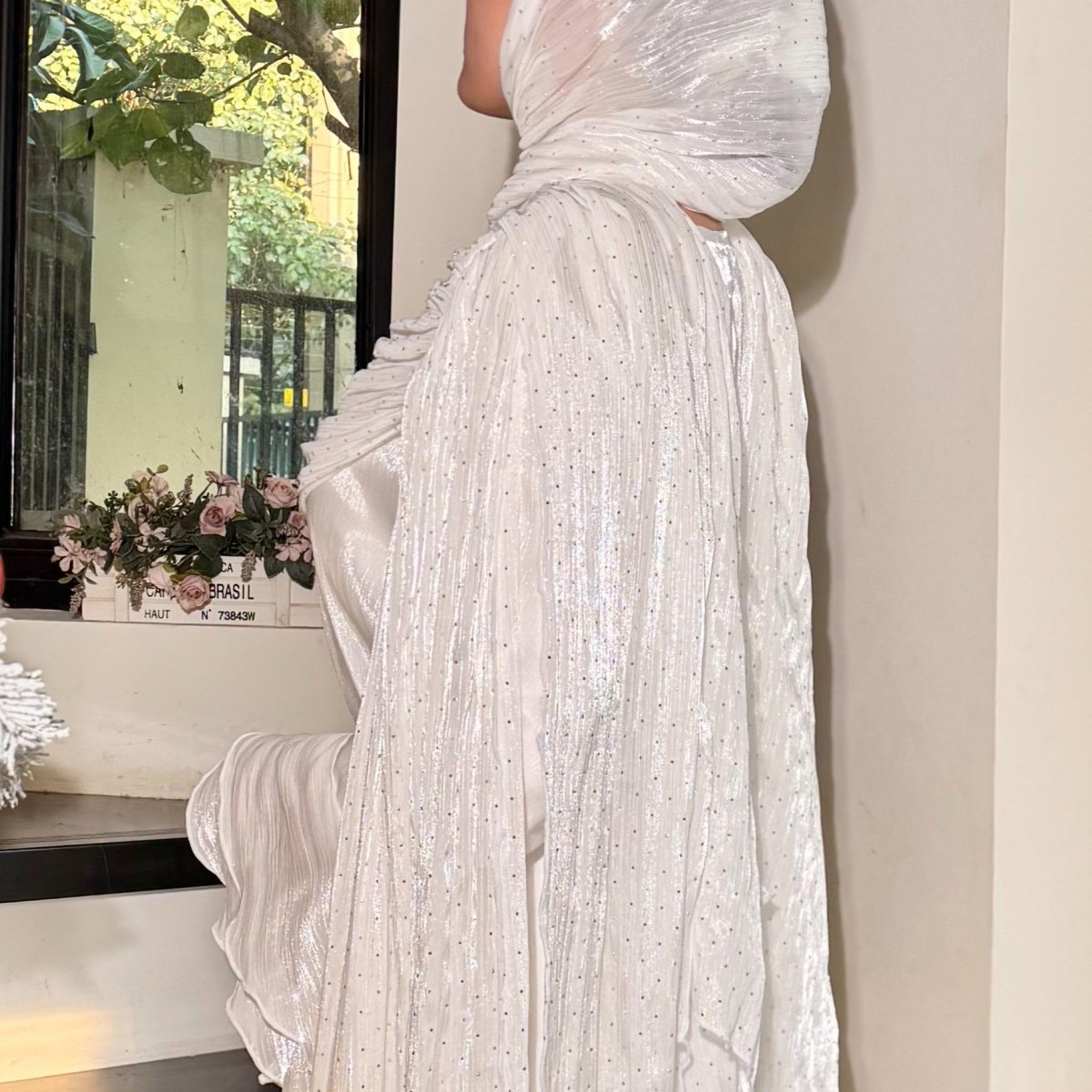 Detail shot of hand-applied rhinestone crystals on pleated silk abaya