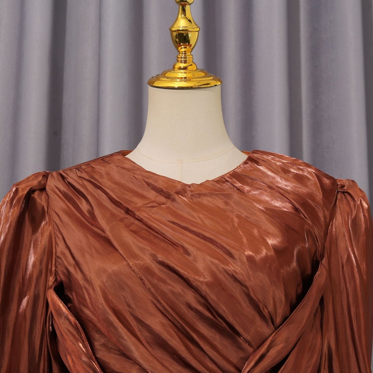 Close-up of diagonal pleat bodice and V-neckline on satin formal dress
