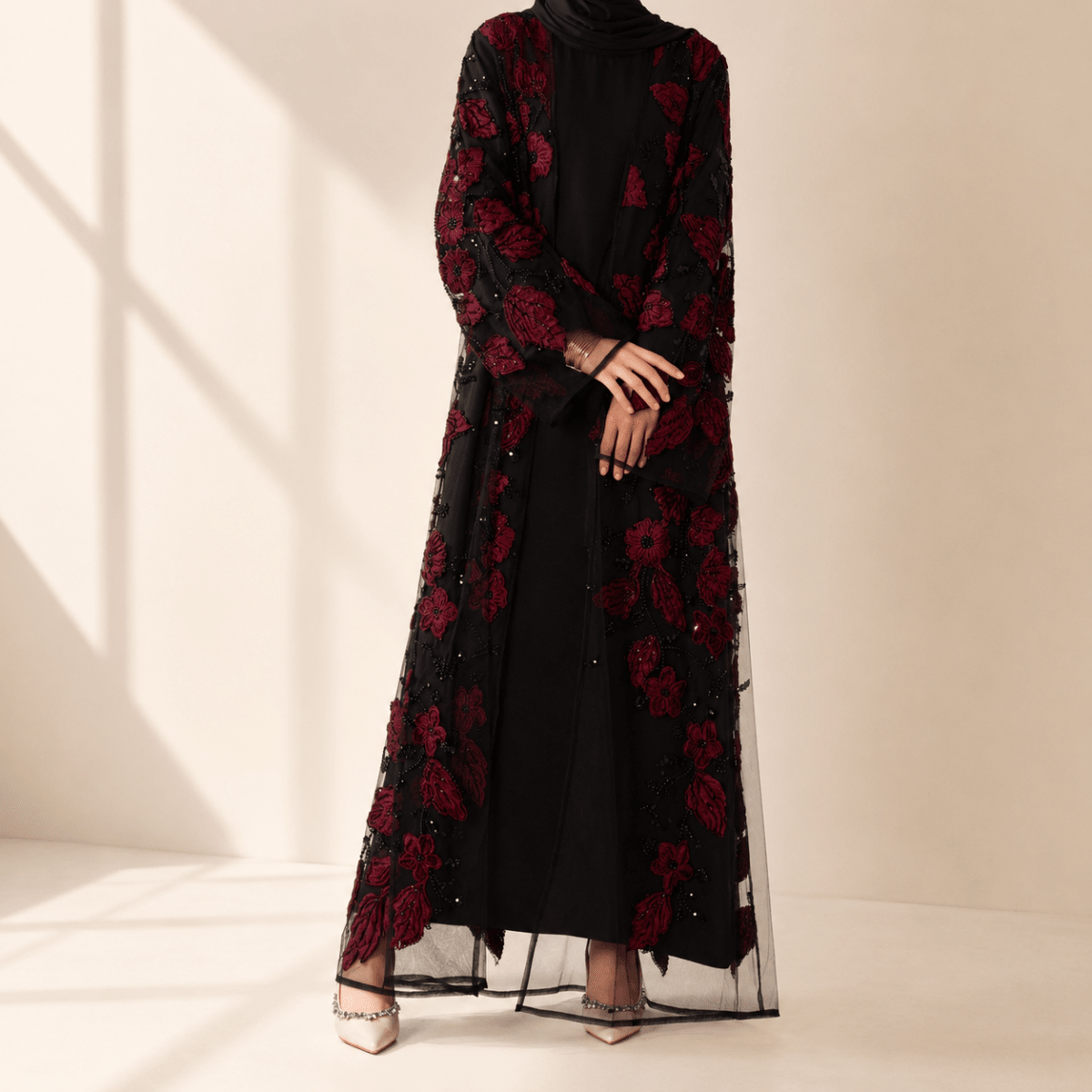 Side profile of flowing open abaya with dimensional floral appliqué